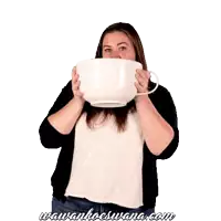 a woman is holding a very large cup with the website www.koeswana.com written below her