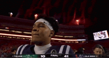 a football player stands in front of a scoreboard that says final