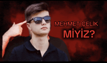 a man wearing sunglasses is pointing at his head with the words mehmet celik miyiz