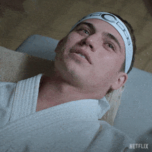 a man wearing a headband that says netflix is laying on a bed