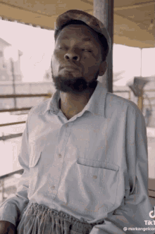 a man wearing a hat and a shirt has tiktok written on the bottom right