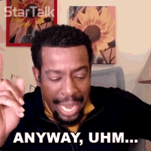 a man with a beard says anyway uhm in front of a picture of sunflowers