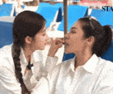 a woman applying makeup to another woman 's face with the word sta visible