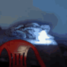 a red chair sits in front of a bed with a blanket on it