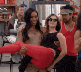 a woman in red pants is being held by a man