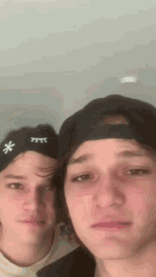 two young men are posing for a picture and one of them is wearing a headband with a snowflake on it