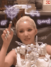 a woman sitting on a couch with mathematical equations written on the wall behind her